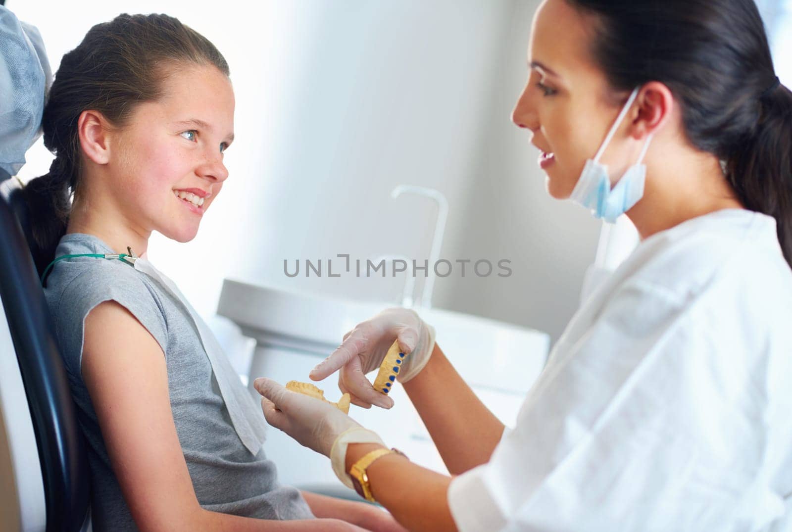 You must be sure to brush here. a female dentist and child in a dentist office