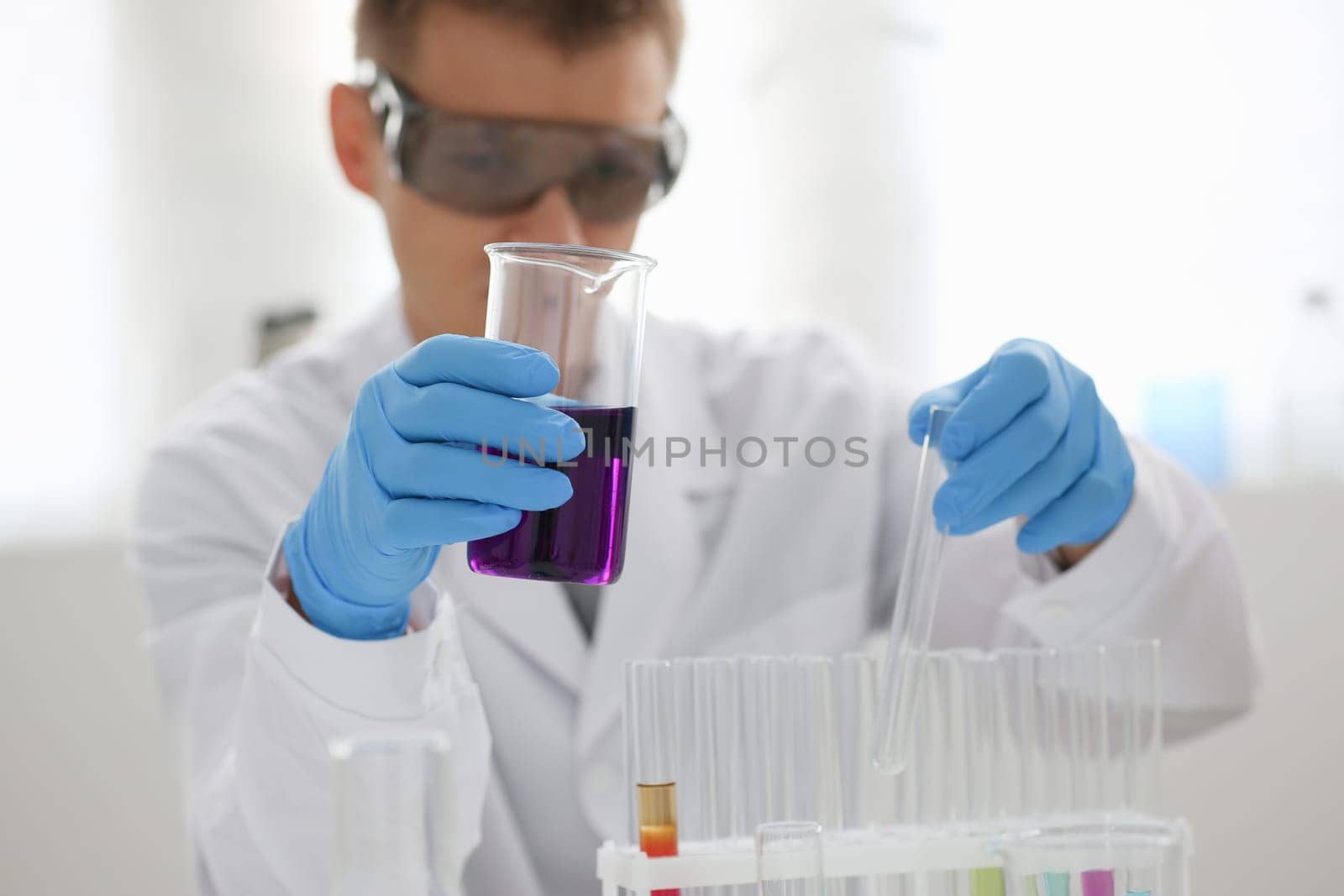 A male chemist holds test tube of glass by kuprevich