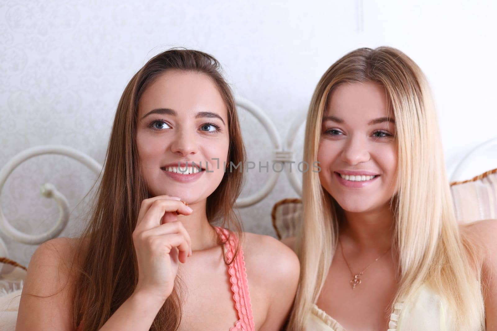Portrait of two beautiful young smiling female by kuprevich