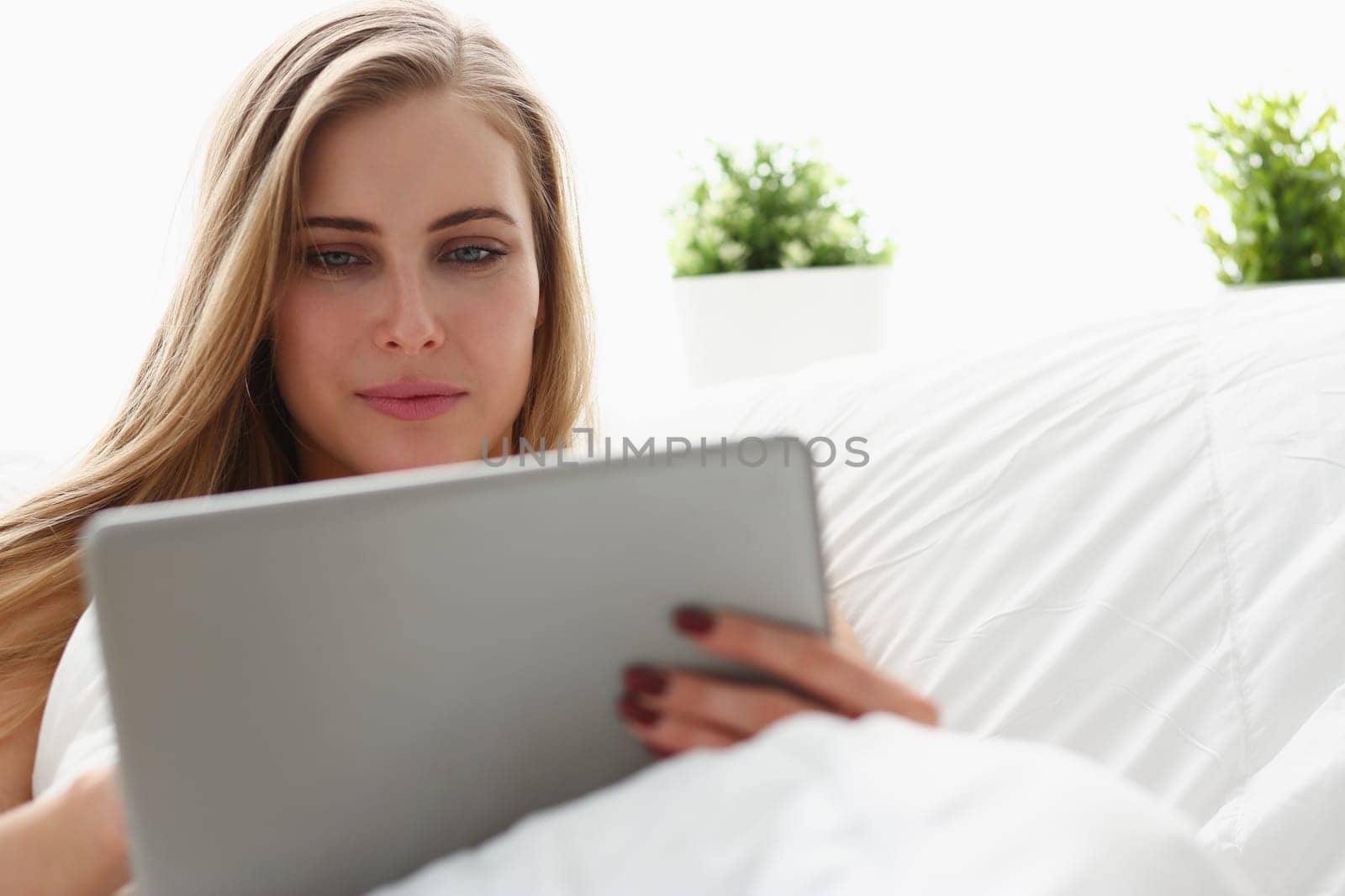 woman work winh laptop stay in bed early morning by kuprevich