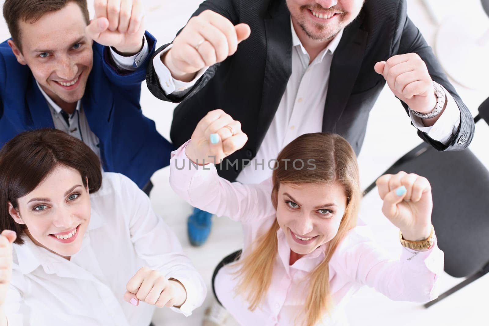 Group of joyful happy people in suits celebrate win with arms up. White collar leadership sale result feel fun good news profit bargain initiative achievement corporate life style deal concept