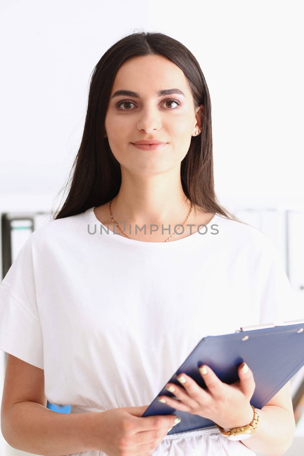 Indian woman worker portrait holding clipboard in hand smiling and looking at camera