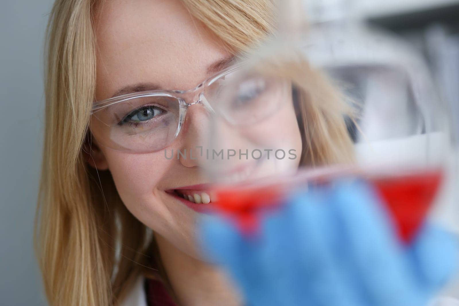 Technician hold in arms in protective gloves sample bottle with poison fluid portrait. Medical worker in uniform use reagent tube for virus infection exam or biological toxic reaction drug creation