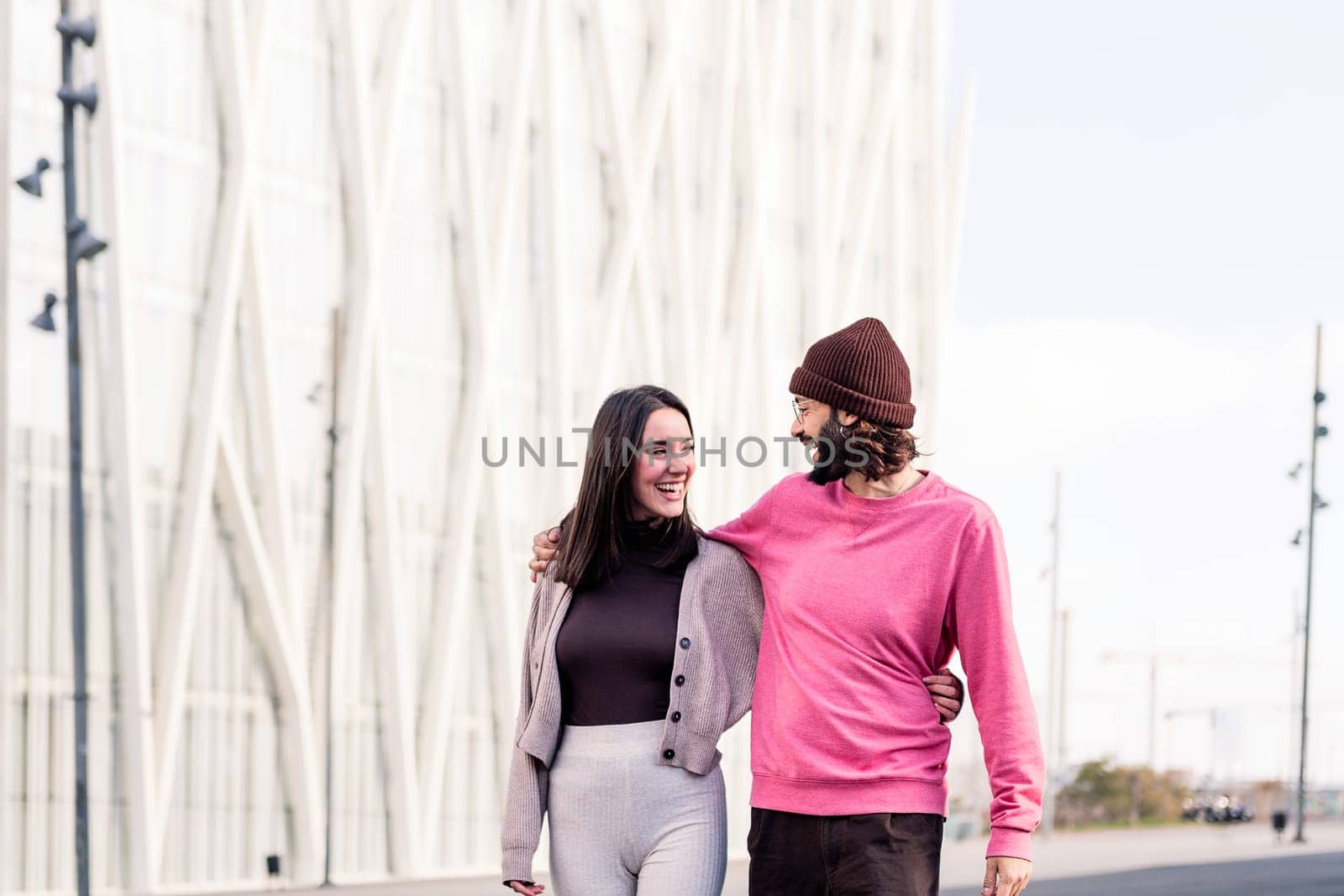 joyful young couple in love sharing a laugh on a romantic walk, concept of friendship and urban lifestyle