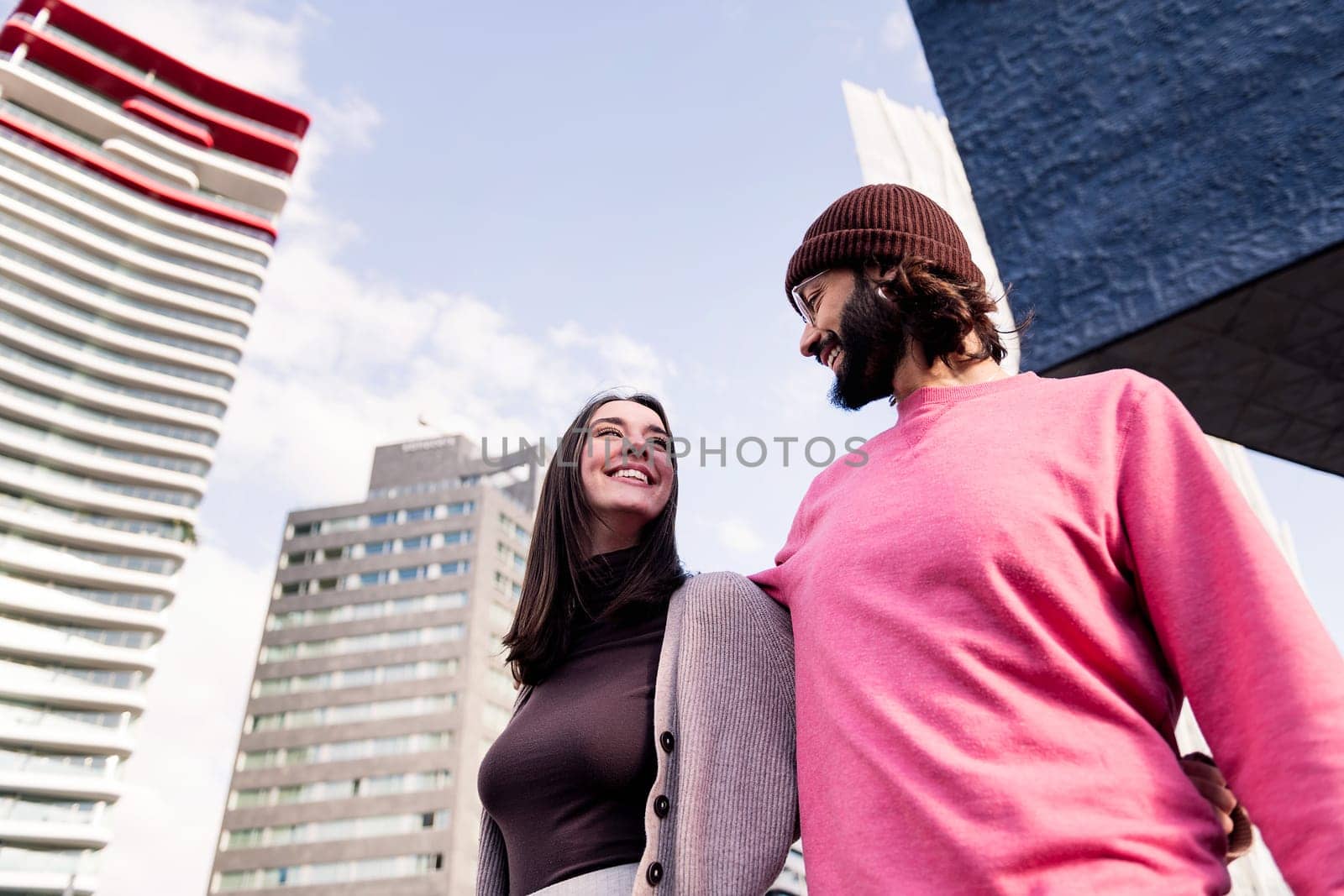 affectionate young couple smiling happy on a romantic walk, concept of friendship and urban lifestyle