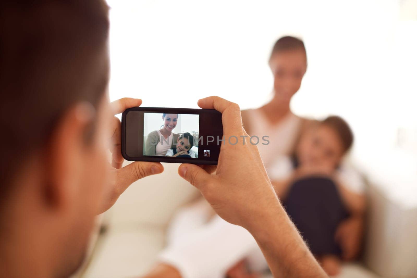 Say cheese. a father taking a picture of his family using his phone. by YuriArcurs