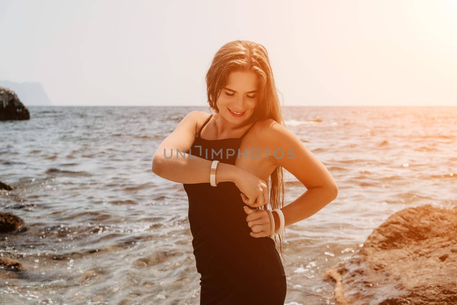 Woman summer travel sea. Happy tourist in hat enjoy taking picture outdoors for memories. Woman traveler posing on the beach at sea surrounded by volcanic mountains, sharing travel adventure journey by panophotograph