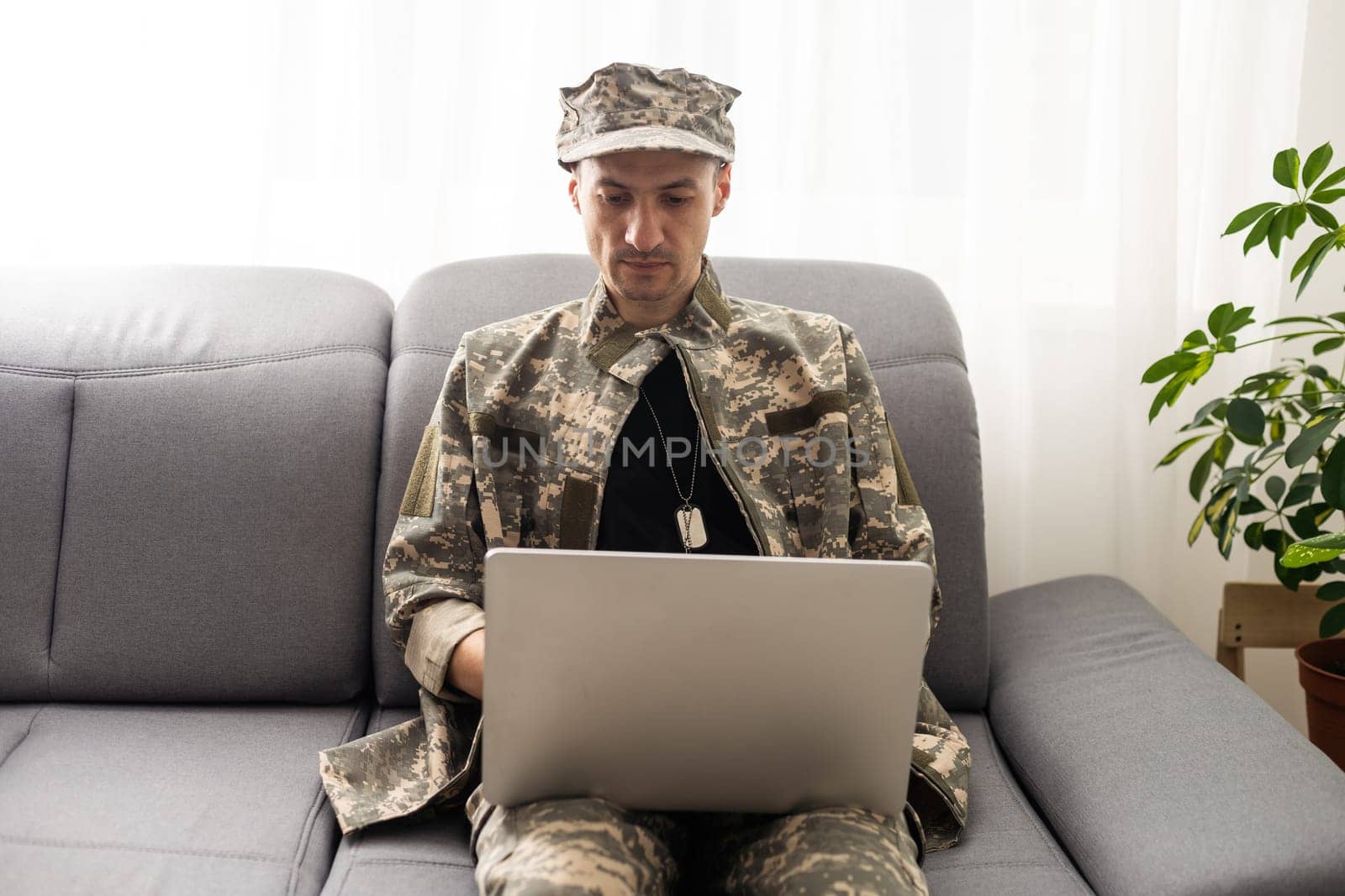 Cropped shot of a mid adult male soldier looking thoughtful while working on his laptop.