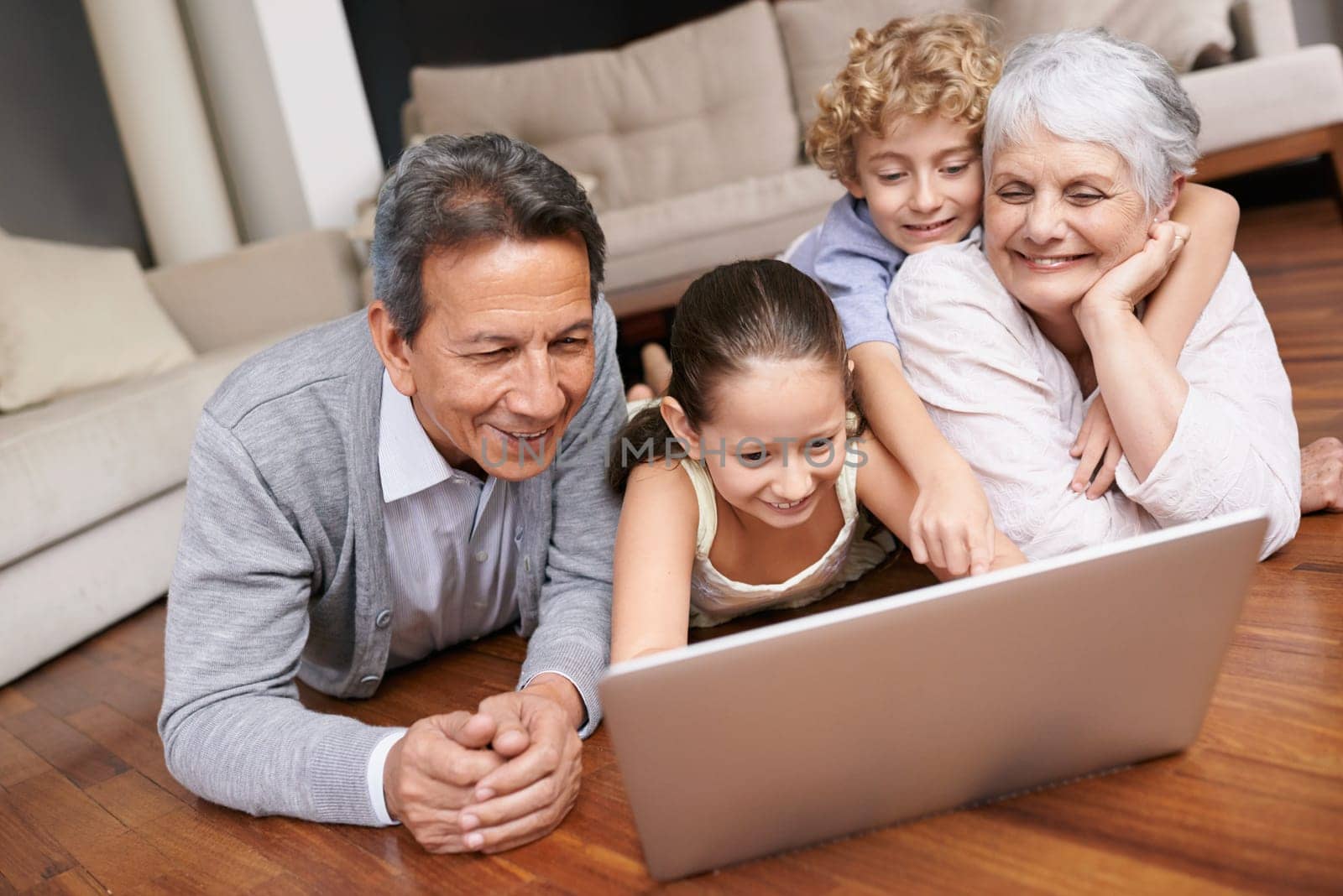 Laptop, floor or grandparents with happy kids for movie streaming online subscription in retirement at home. Children siblings, relax or grandmother watching videos on internet with a senior old man by YuriArcurs