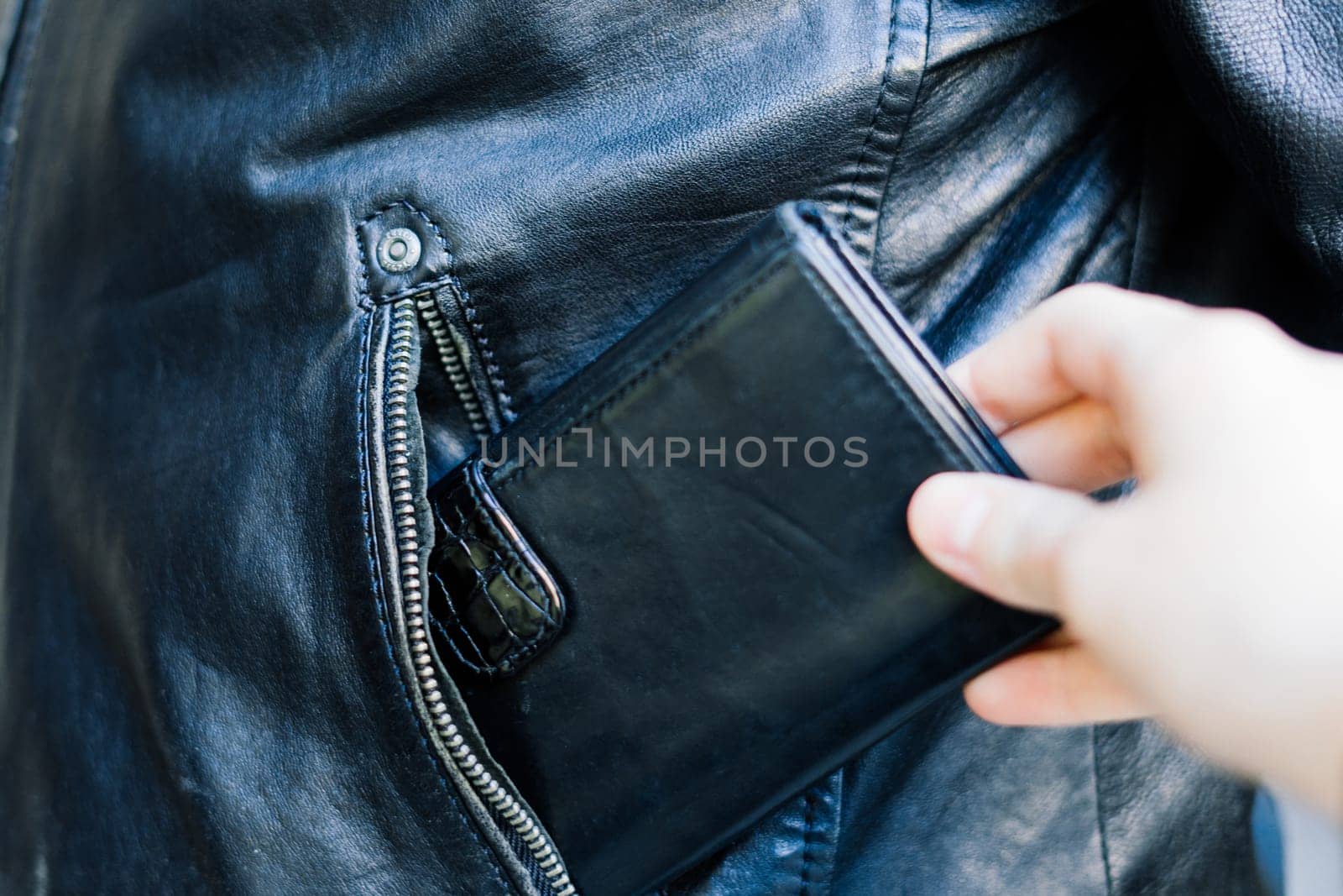 From the pocket of jacket the thief pulls out a card banknote money purse wallet. by Zelenin