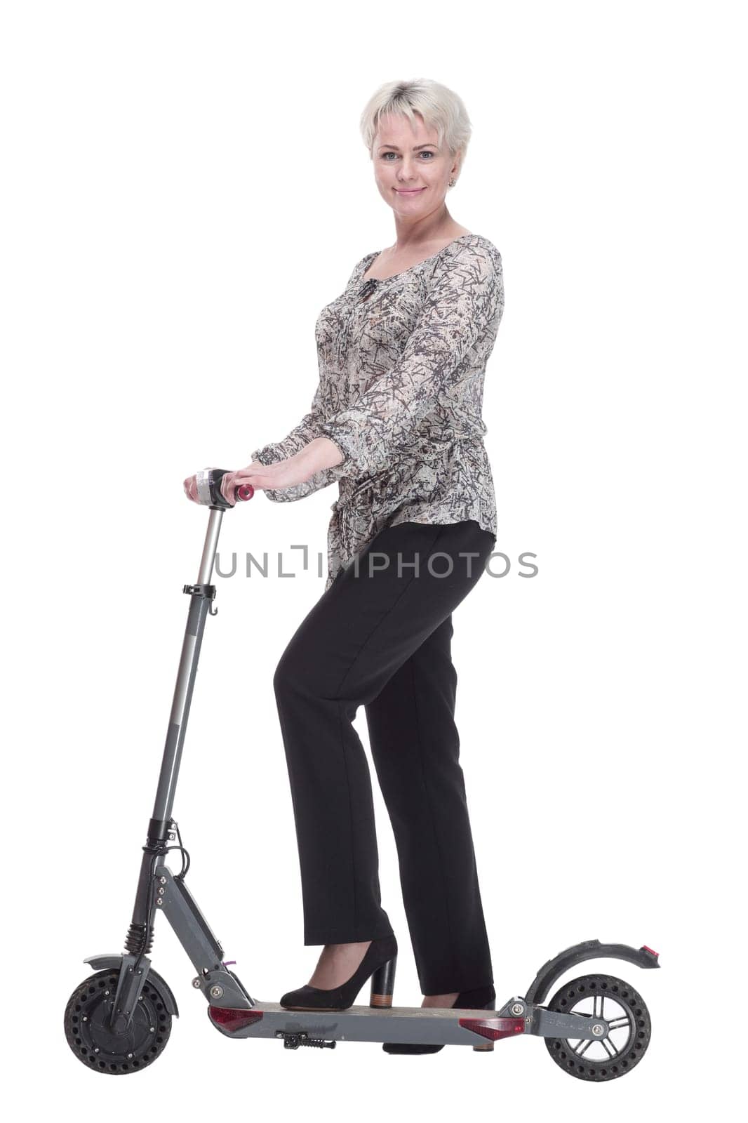 side view. elegant young woman with an electric scooter looking at you . isolated on a white background.