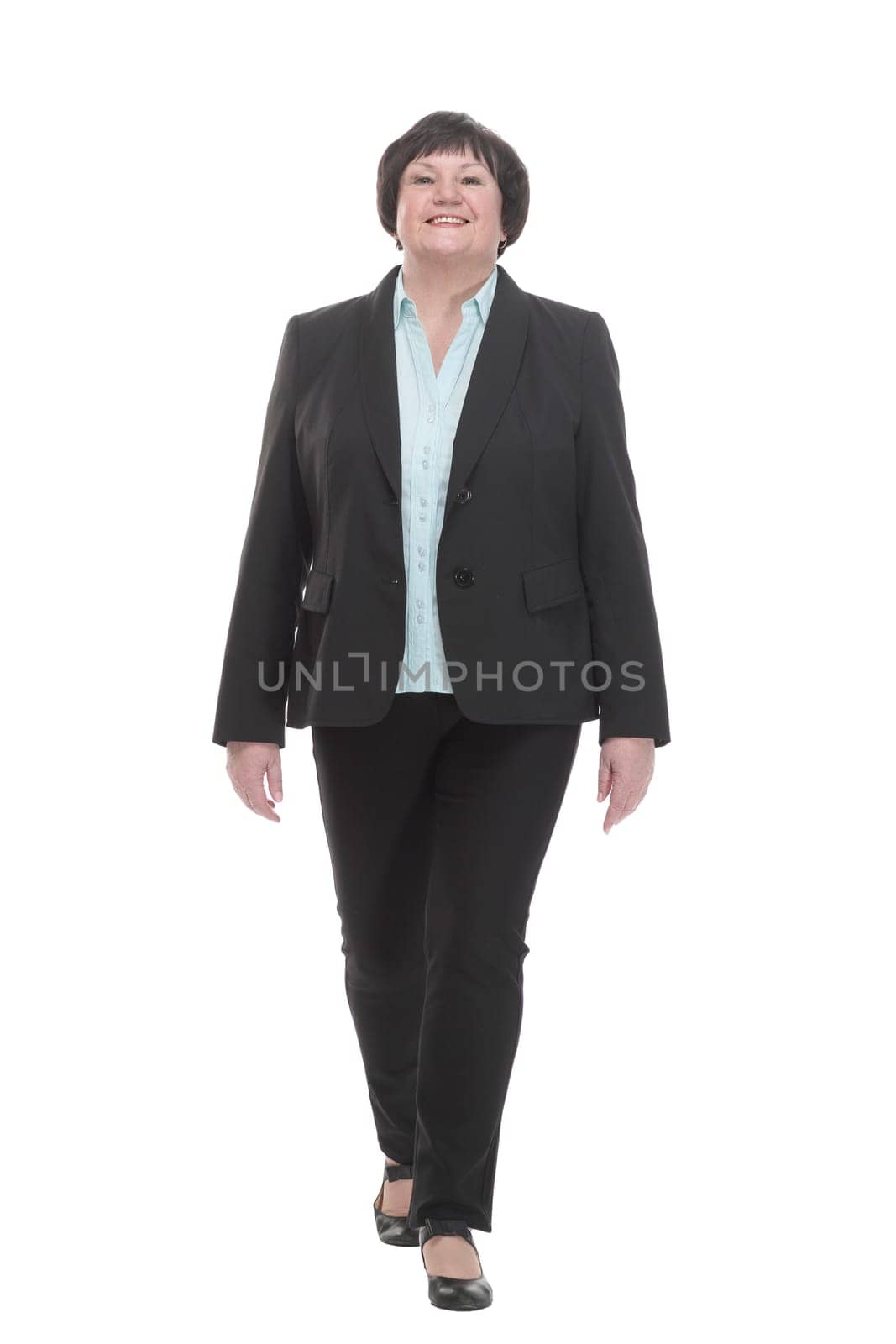 Mature business woman in a pantsuit striding forward. isolated on a white background.