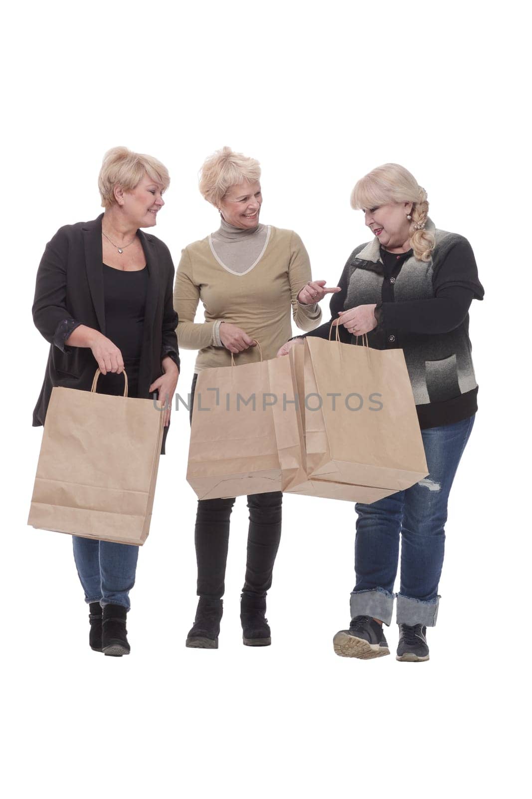 in full growth. three happy women with shopping bags. isolated on a white background.