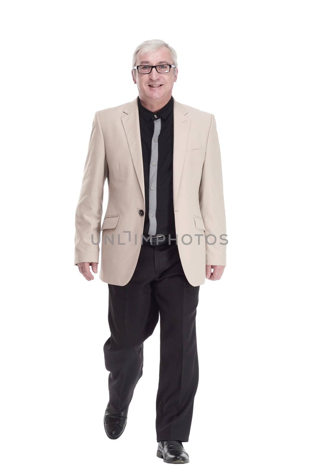 intelligent mature man in a white jacket walking forward . isolated on a white background.