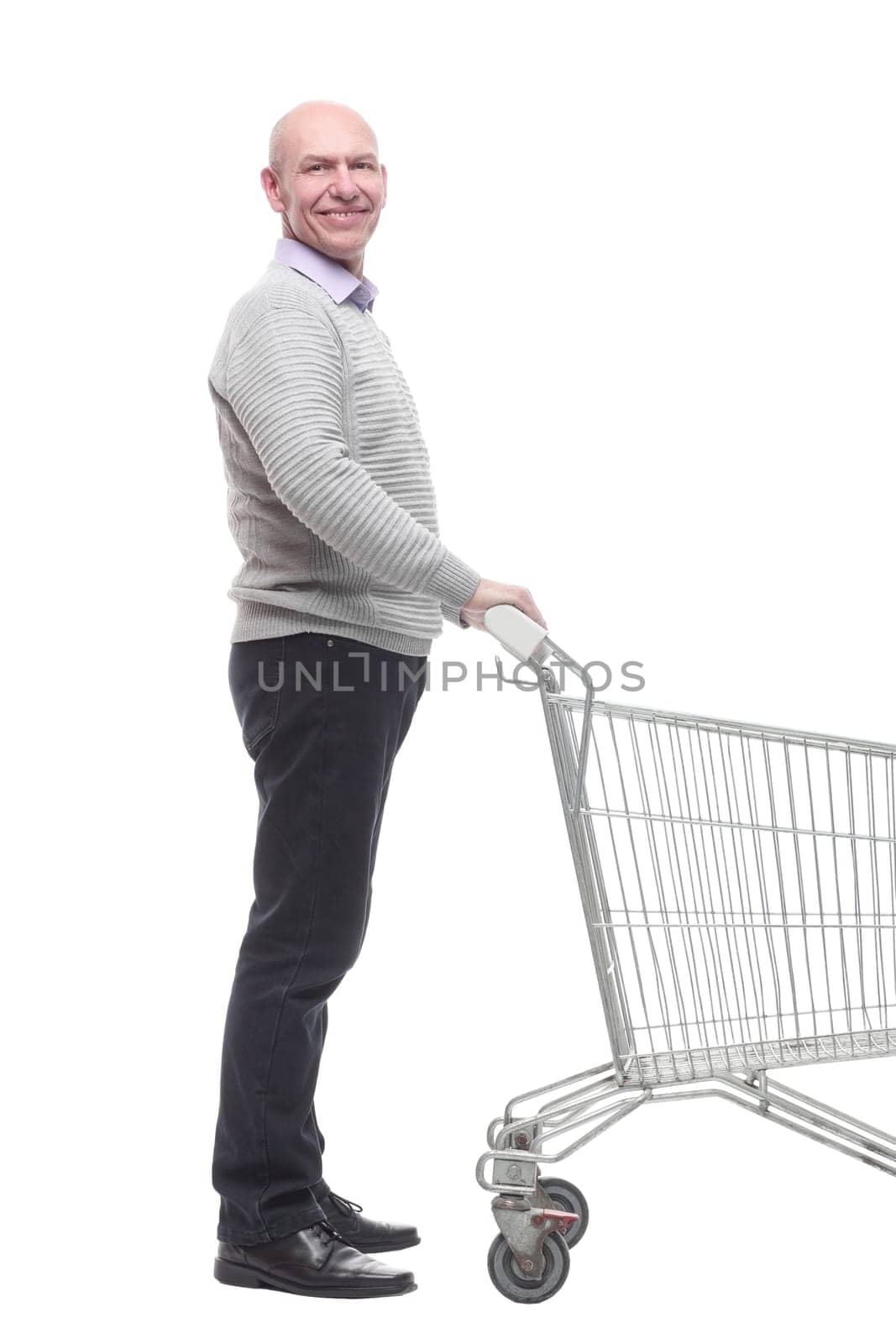 in full growth. a happy man with a shopping cart. isolated on a white background.