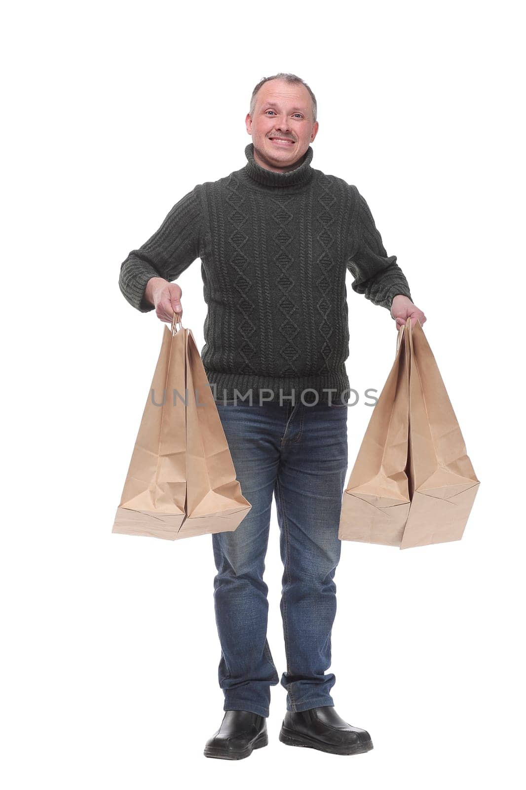 Full length portrait of a young casual man holding shopping bags isolated against white background