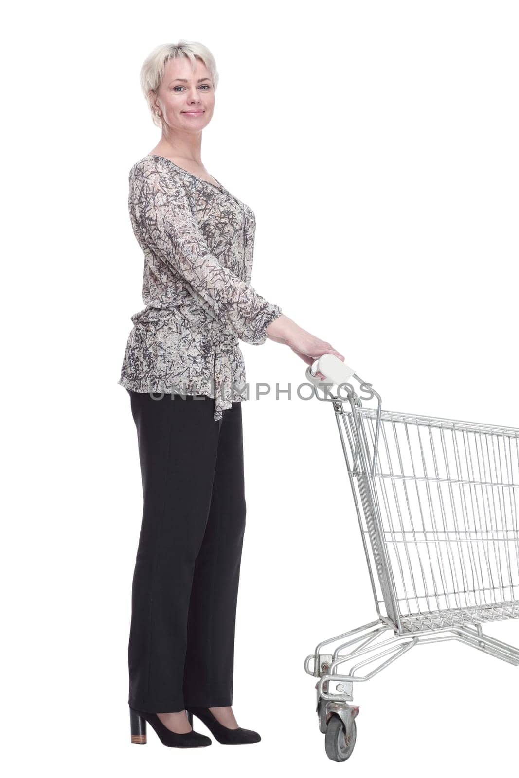 side view. elegant young woman with a shopping cart looking at you . isolated on a white background.