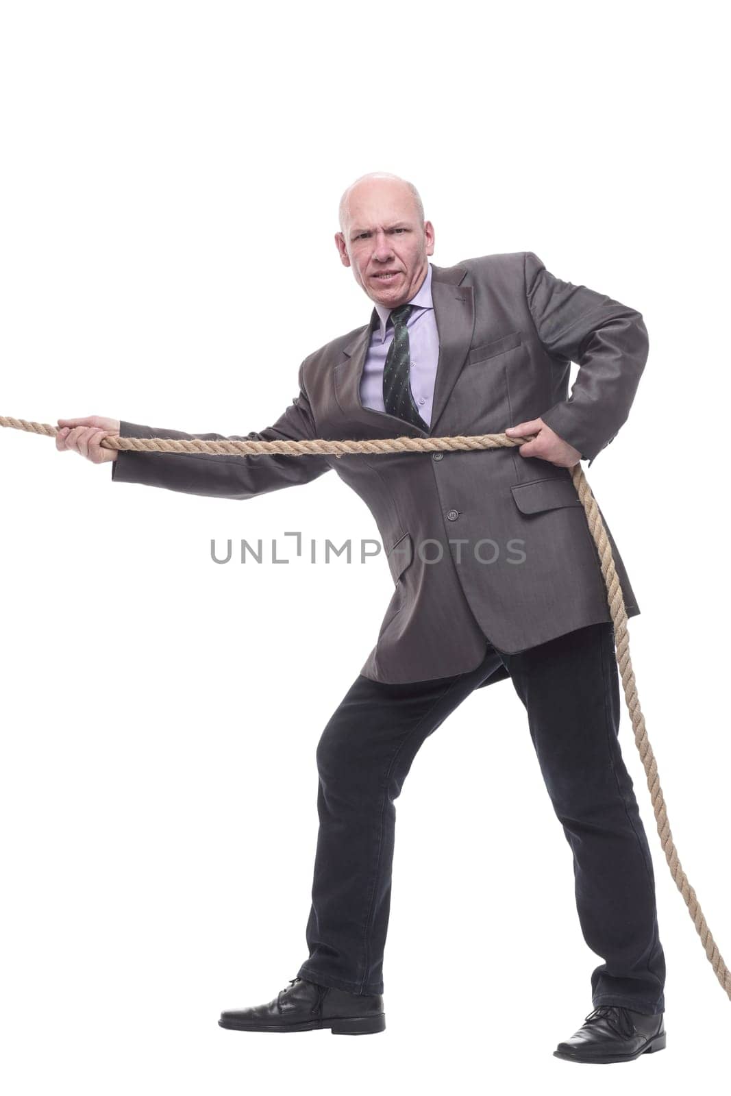 in full growth. business man pulls a rope. isolated on a white background.