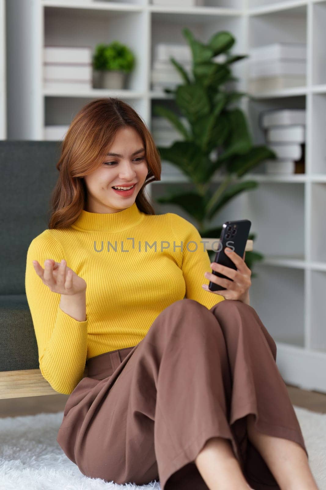Confident woman executive using smart phone, having video conference call virtual meeting, advisor finance, research, fund by itchaznong