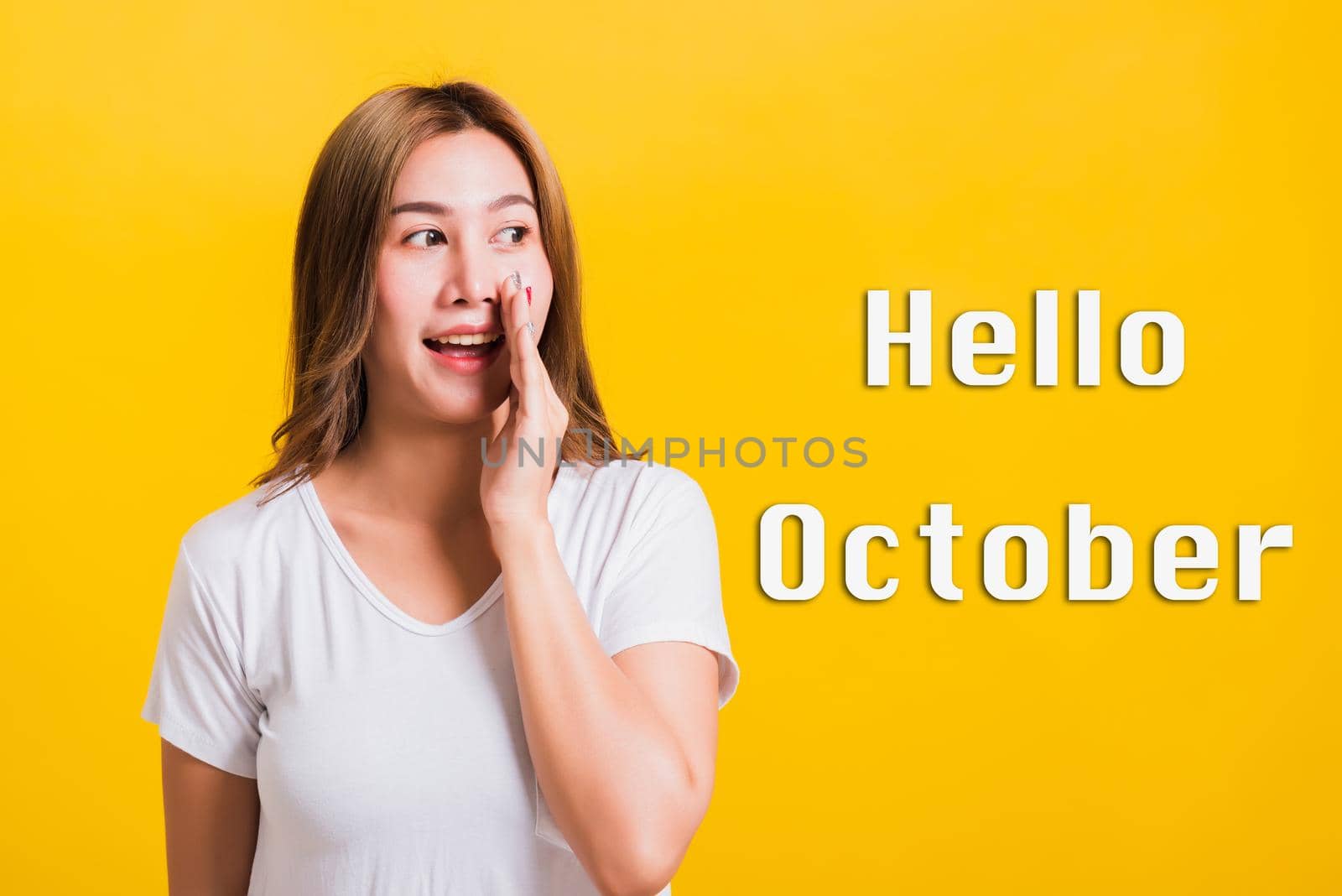 Hello October, Asian Thai happy portrait beautiful young woman standing hold a hand on mouth talking whispering secret by Sorapop