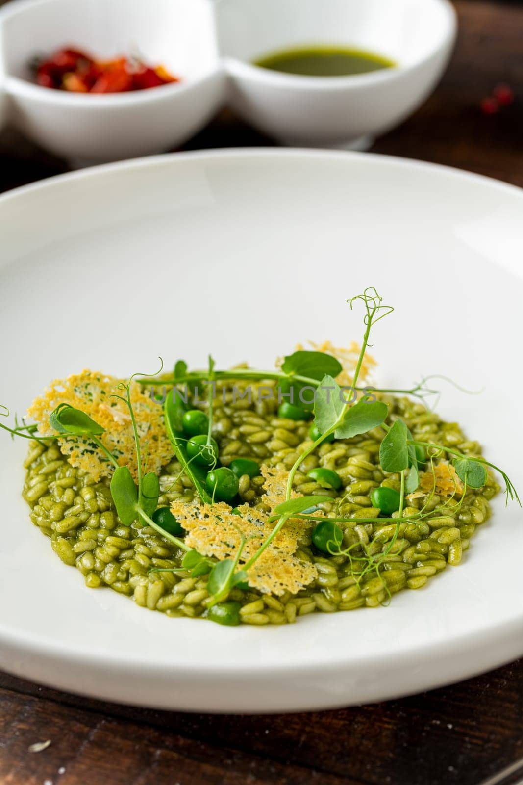 Pea risotto on a white porcelain plate in a fine dining restaurant