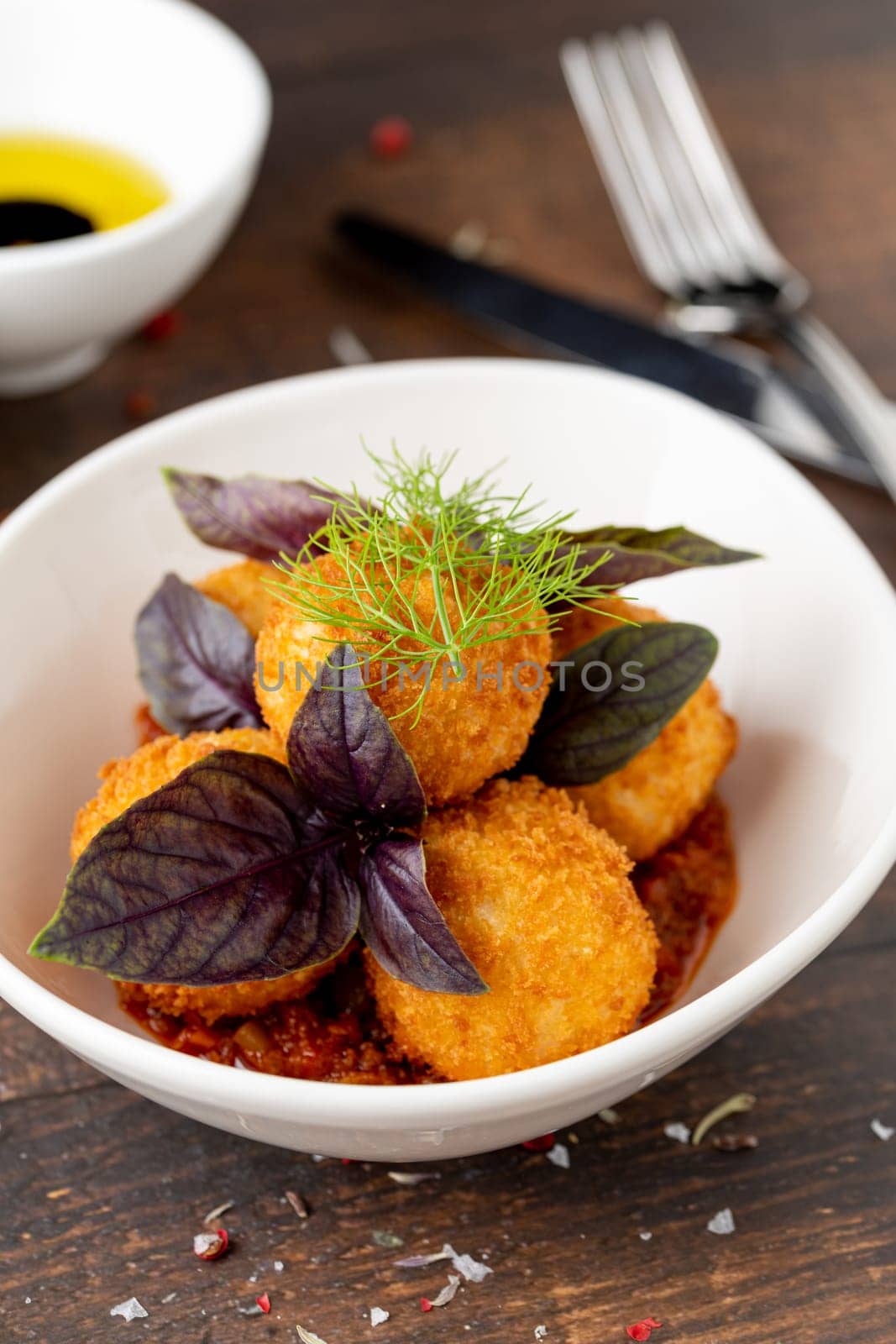 Homemade Fried Sicilian Arancini stuffed with meat, with tomato sauce