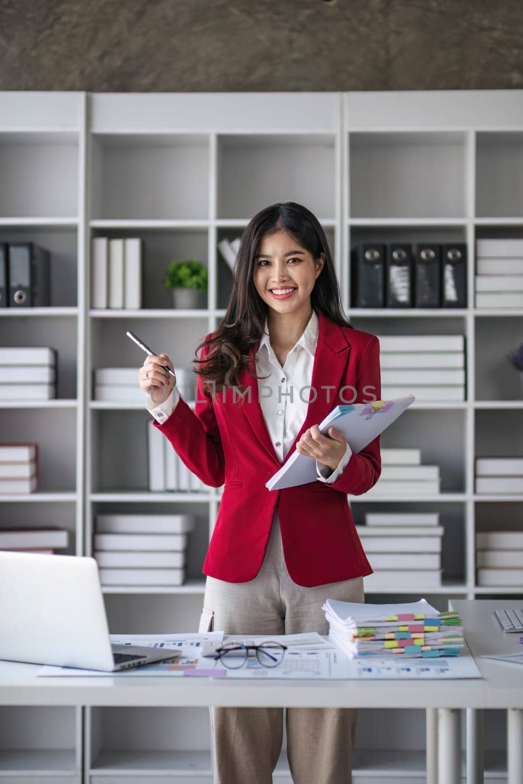 Young confident smiling Asian business woman leader,successful entrepreneur,elegant professional company executive ceo manager, wearing suit standing in office..