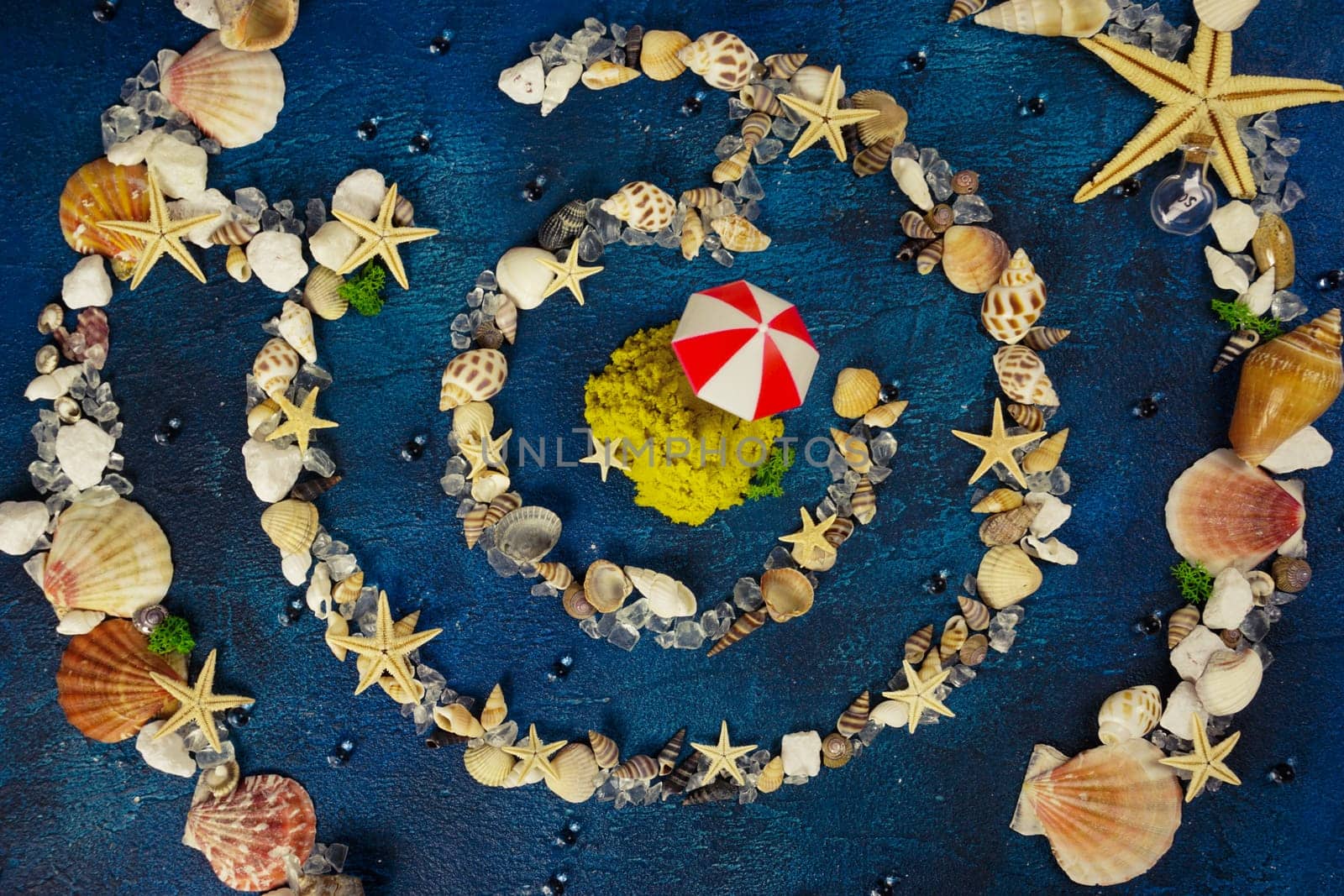 Creative photography. A maze of shells and starfish on a blue background. The concept of a beach holiday.