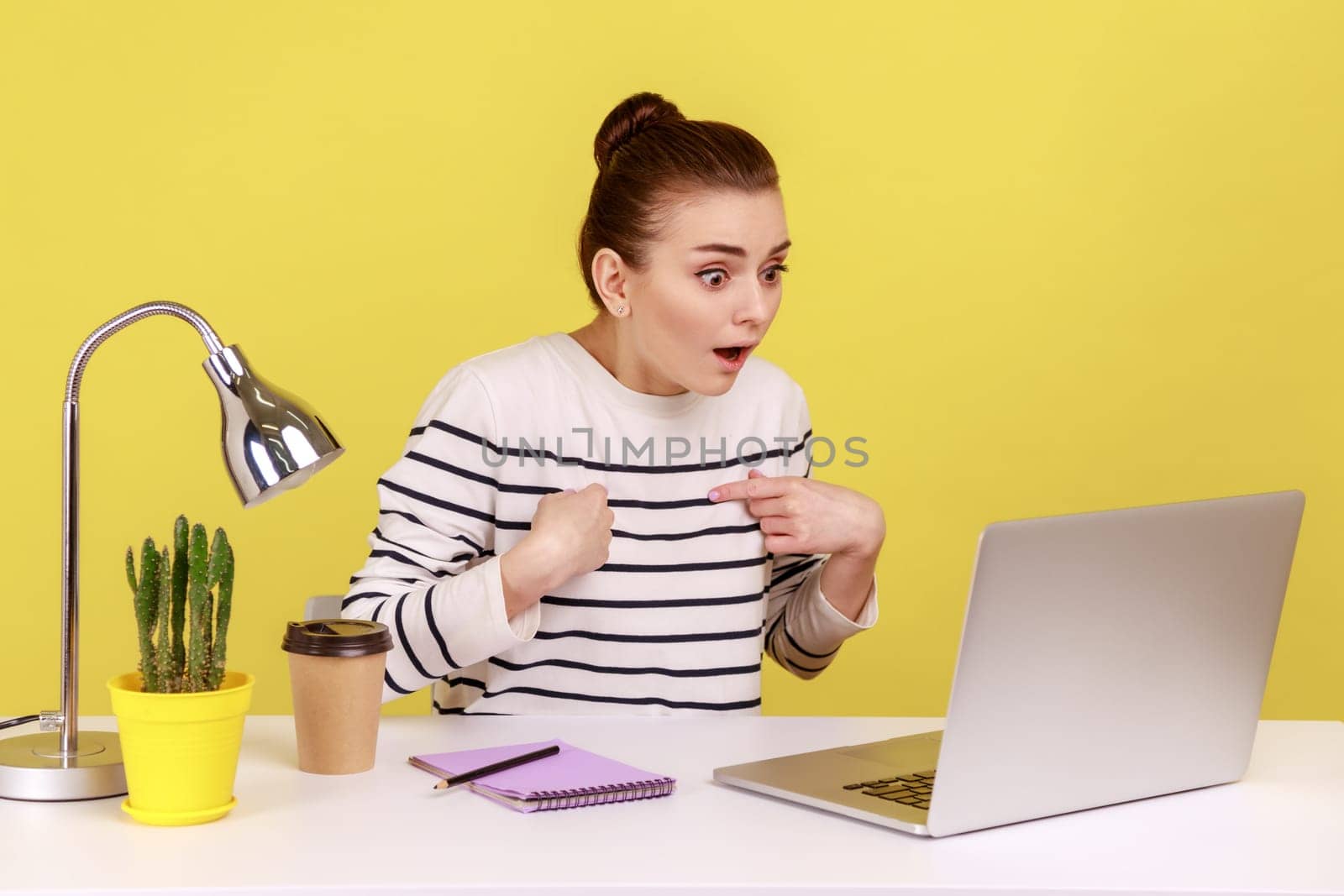 Woman with shocked expression looking at laptop screen with open mouth, talking on video call. by Khosro1