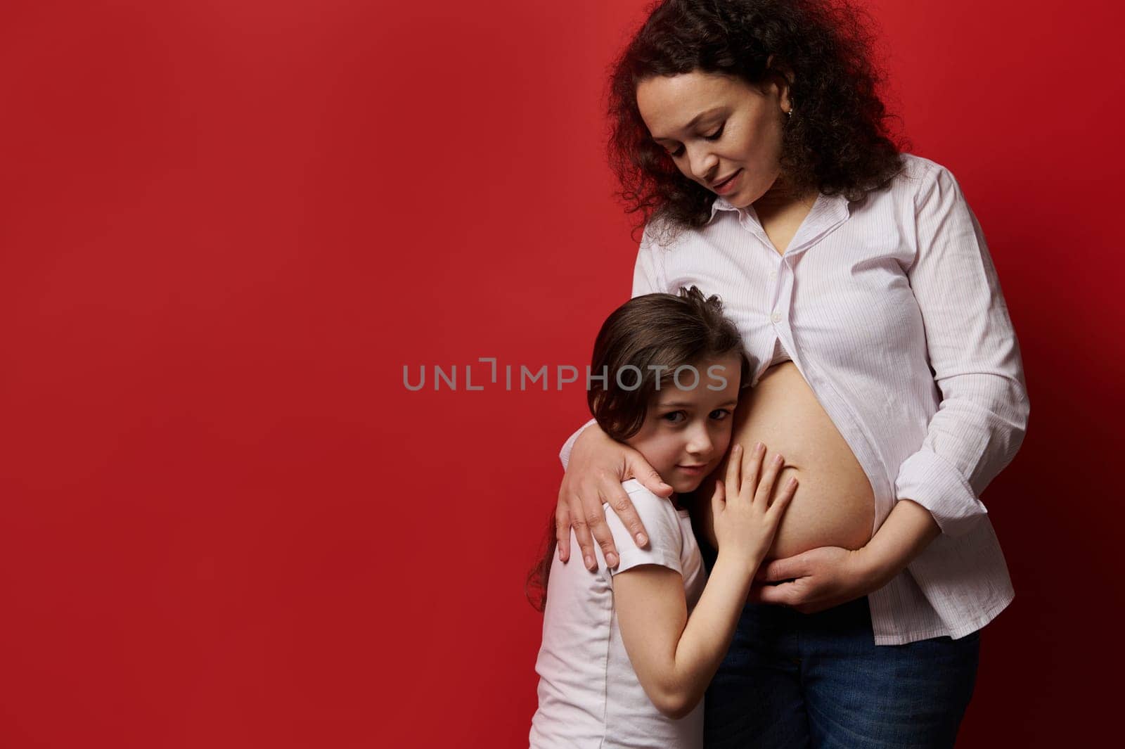 Gravid woman, pregnant expectant mother with naked belly gently hugging her lovely daughter. Pregnancy Family Maternity by artgf