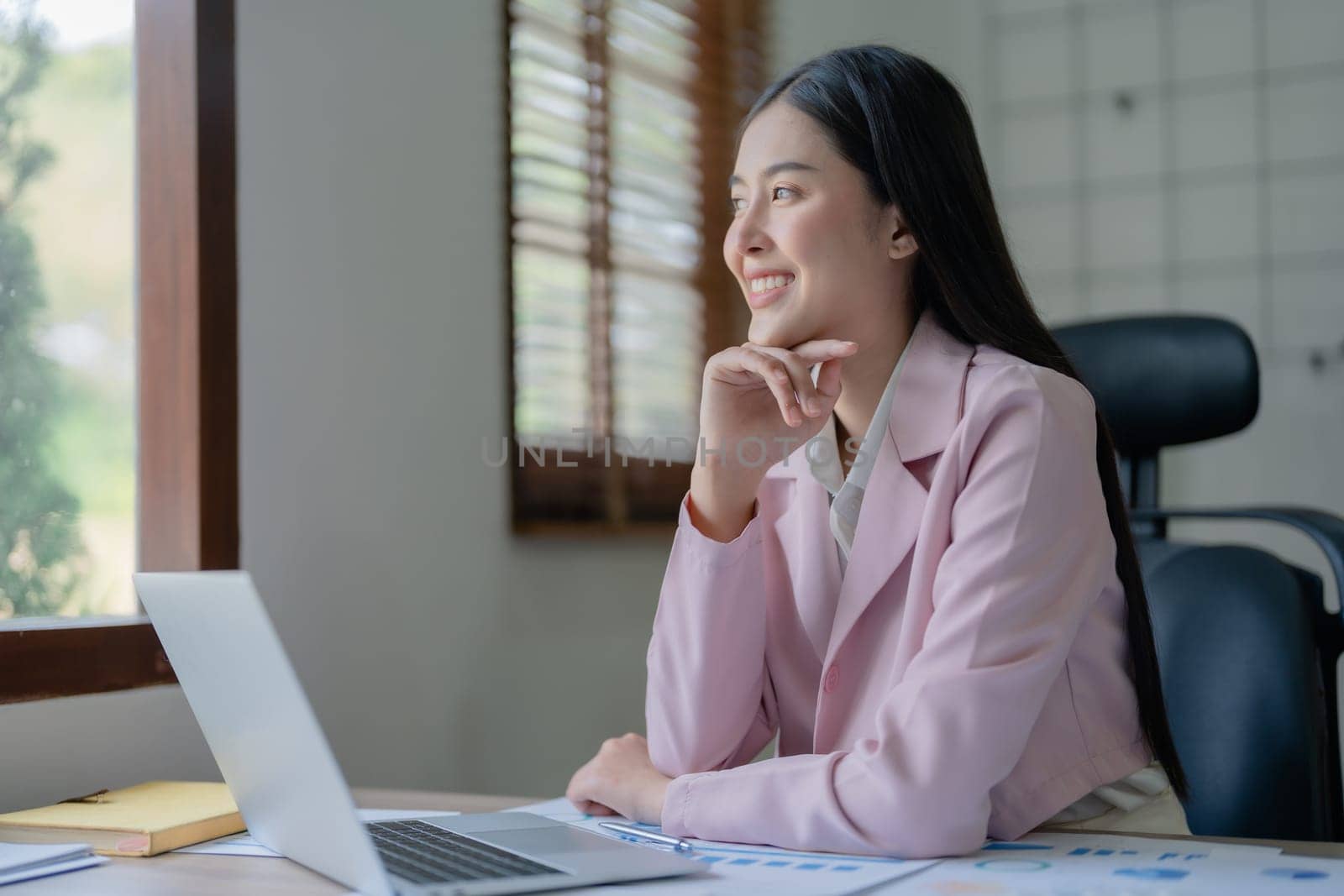 Excited businesswoman using computer laptop while in office, business concepts