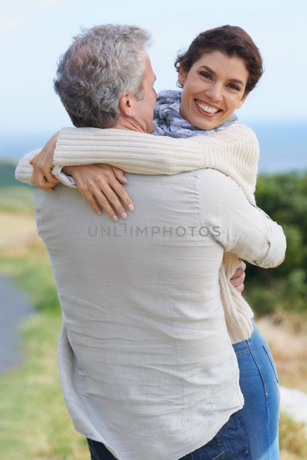 Love in the sunshine. A loving couple hugging each other affectionately outdoors