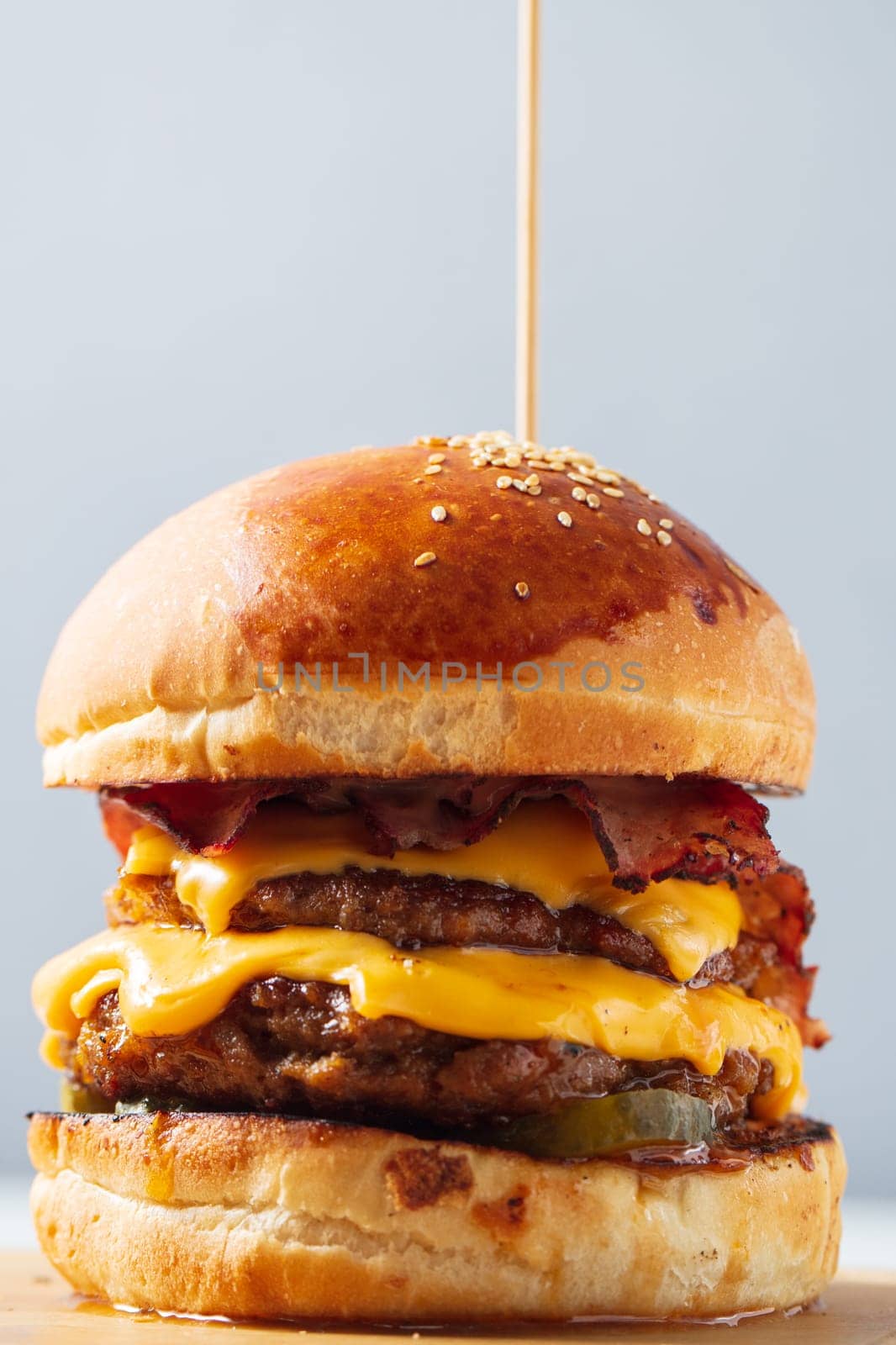 Burger. Double cutlet, double cheddar cheese, bacon, deep-fried onions, pickles, sauce and craft bun. High quality photo