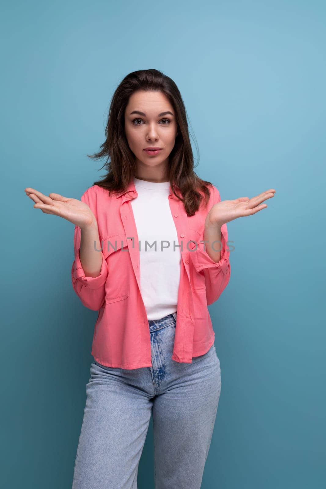 bright stylish brunette young woman in a fashionable shirt, t-shirt and jeans.