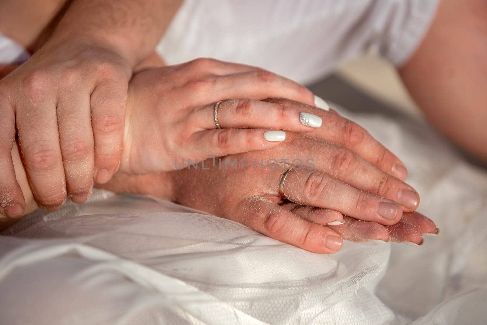 Man and woman, newlyweds holding hands with blurred background. by Kai_Grim