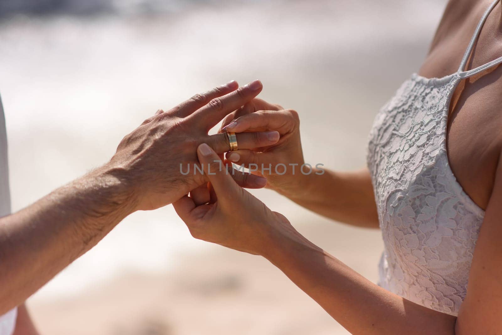 Newlyweds exchange rings, groom puts the ring on bride's hand