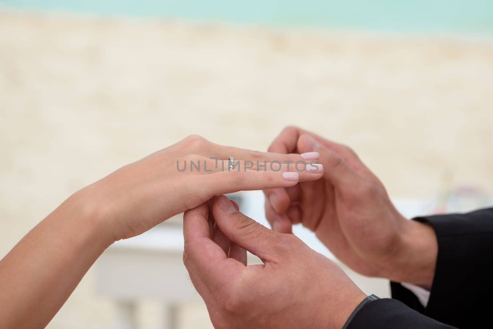Newlyweds exchange rings, groom puts the ring on the bride's hand. by Kai_Grim