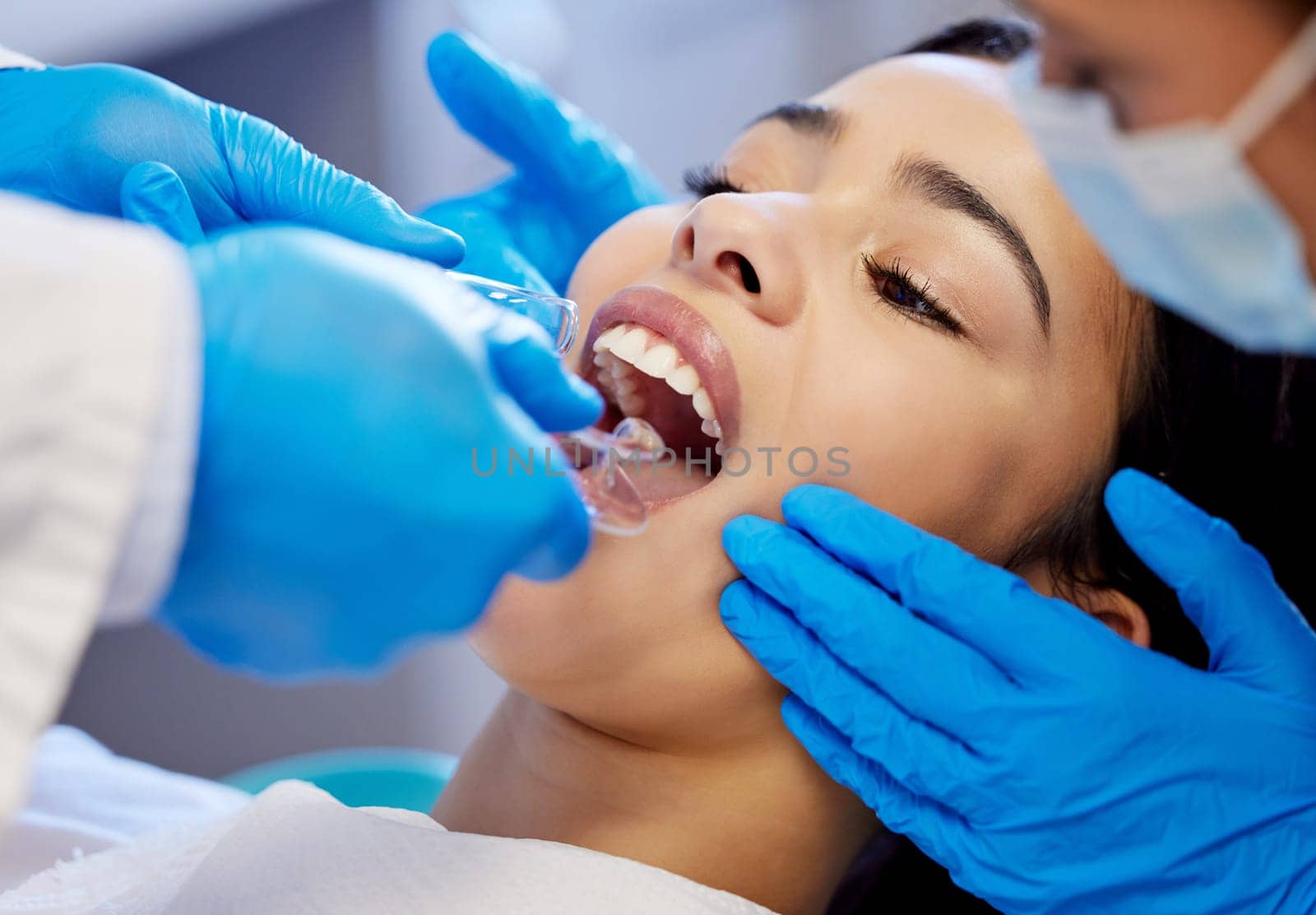 Those are some healthy looking teeth. a young woman having a dental procedure performed on her