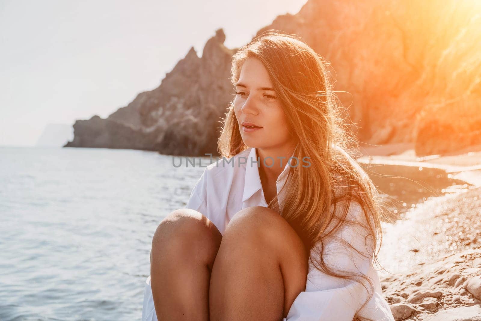 Young woman in red bikini on Beach. Girl lying on pebble beach and enjoying sun. Happy lady with long hair in bathing suit chilling and sunbathing by turquoise sea ocean on hot summer day. Close up by panophotograph