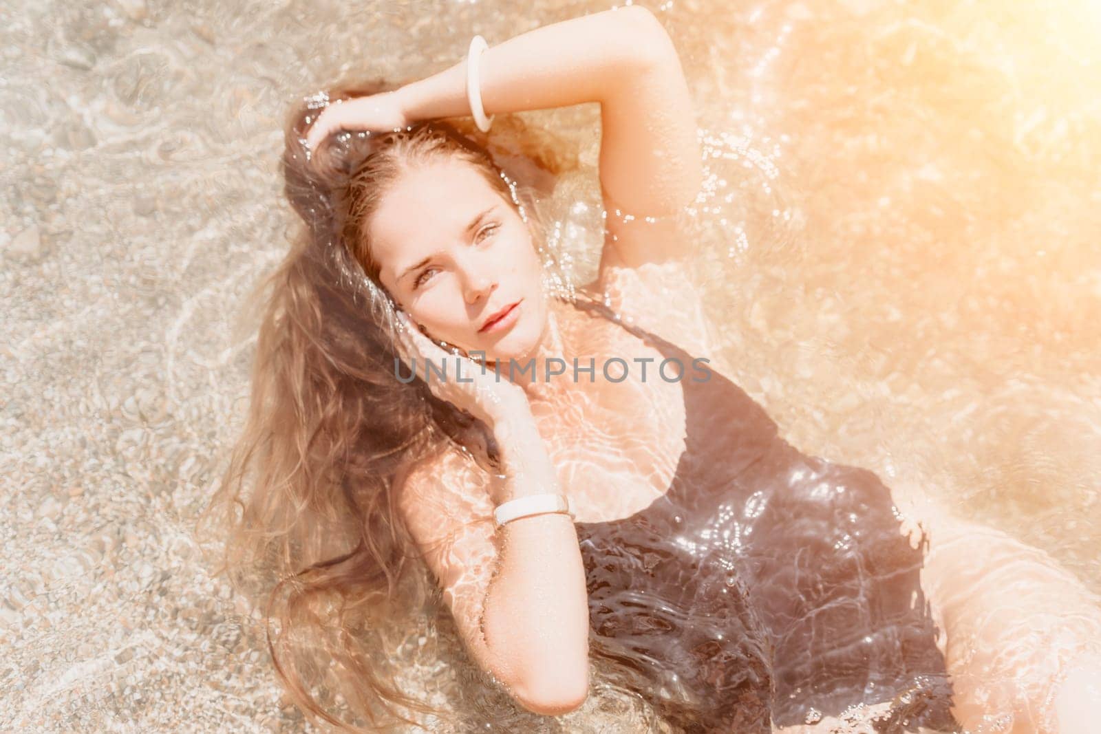 Woman travel sea. Young Happy woman in a long red dress posing on a beach near the sea on background of volcanic rocks, like in Iceland, sharing travel adventure journey