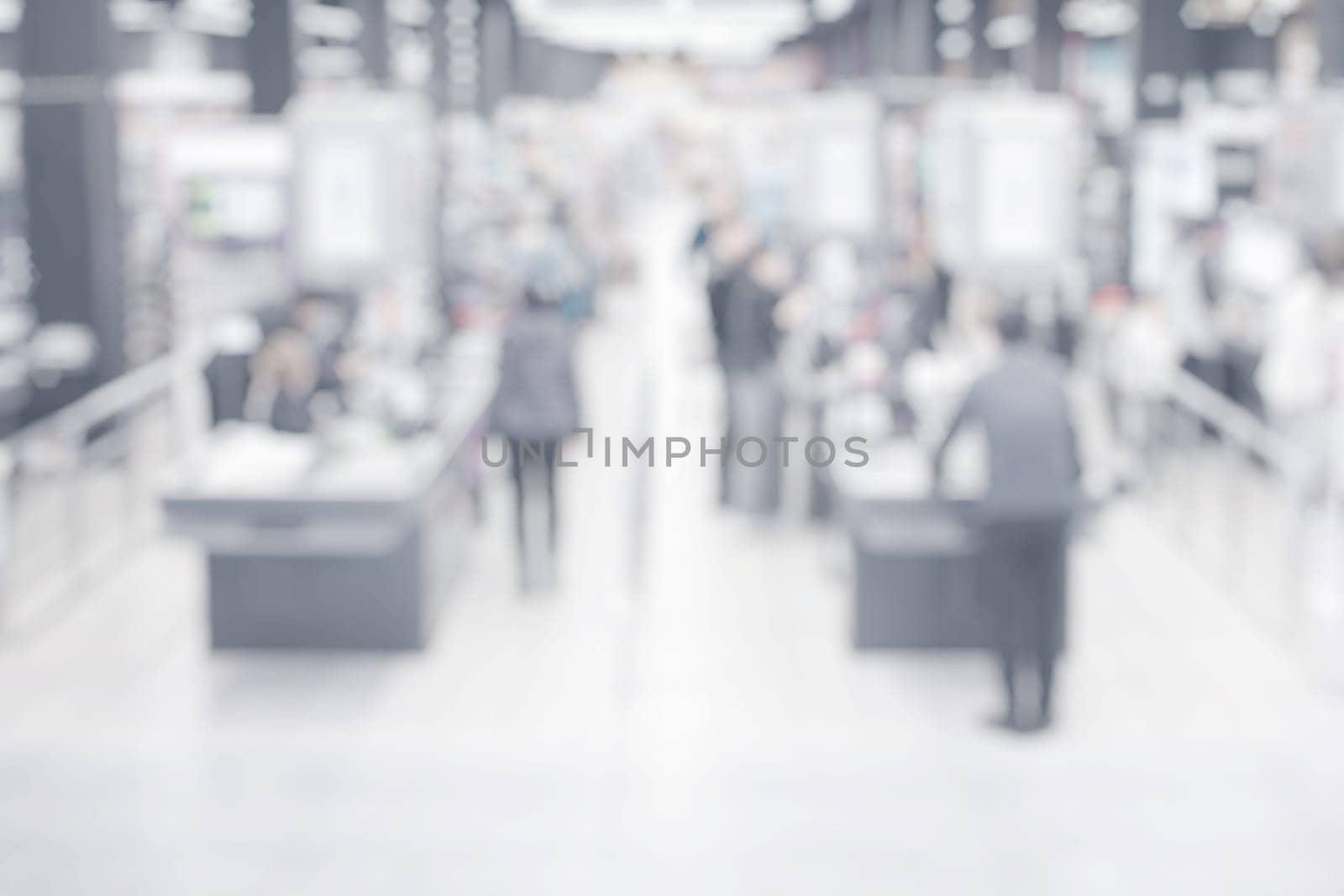 Abstract blurred background with people at grocery store checkout counters.