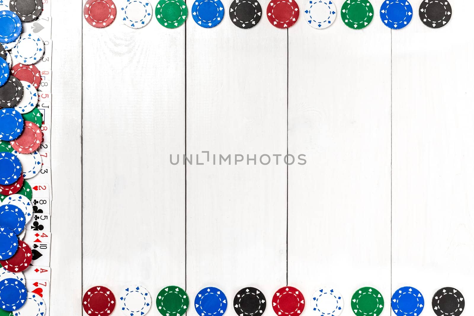 Playing cards and poker chips on white wooden background. Top view. Copyspace. Poker.