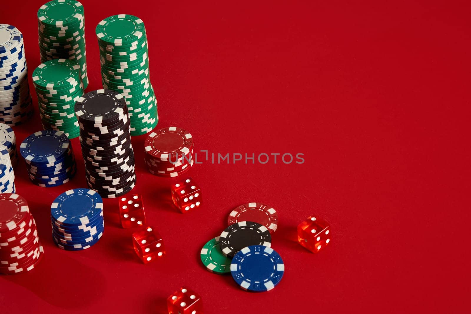 Poker chips on red background. Group of different poker chips. Casino background. Copy space. Still life