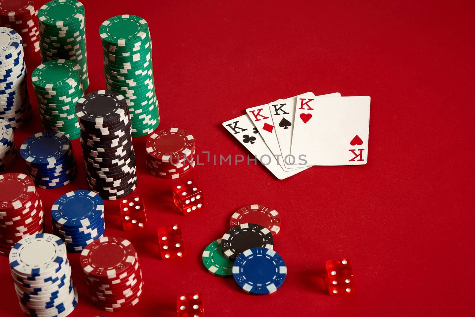 Casino gambling poker equipment and entertainment concept - close up of playing cards and chips at red background. Four of a Kind. Casino background. Copy space. Still life