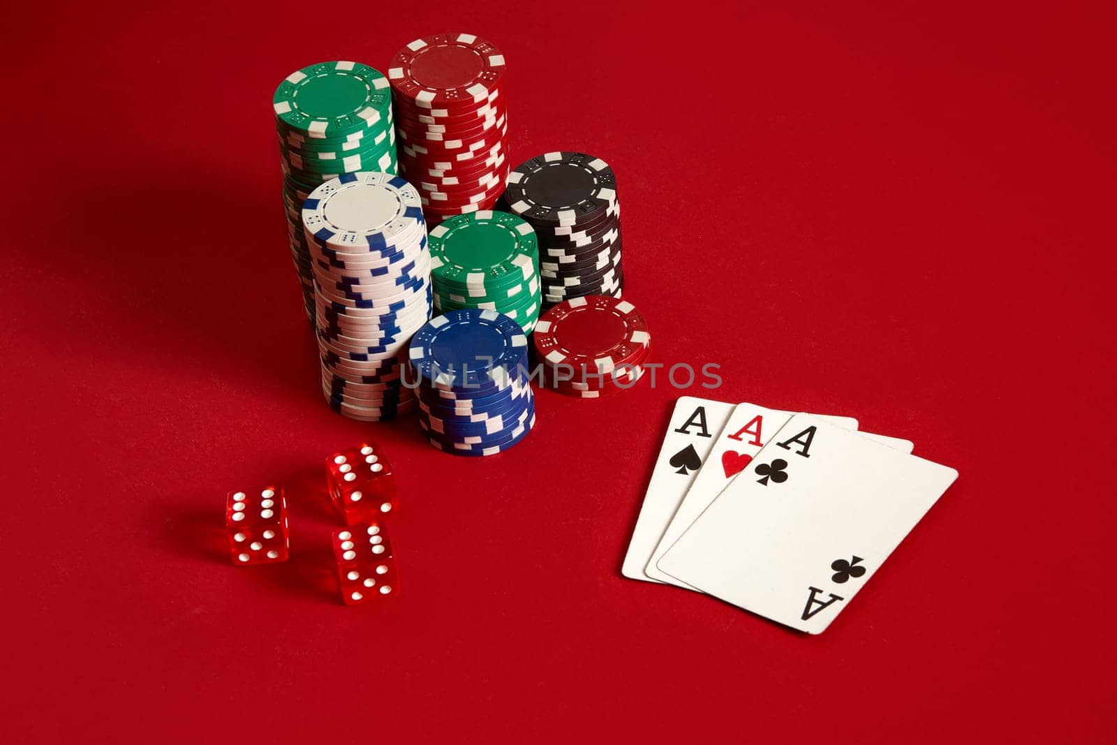 Casino gambling poker equipment and entertainment concept - close up of playing cards and chips at red background. Three of a Kind. Casino background. Copy space. Still life