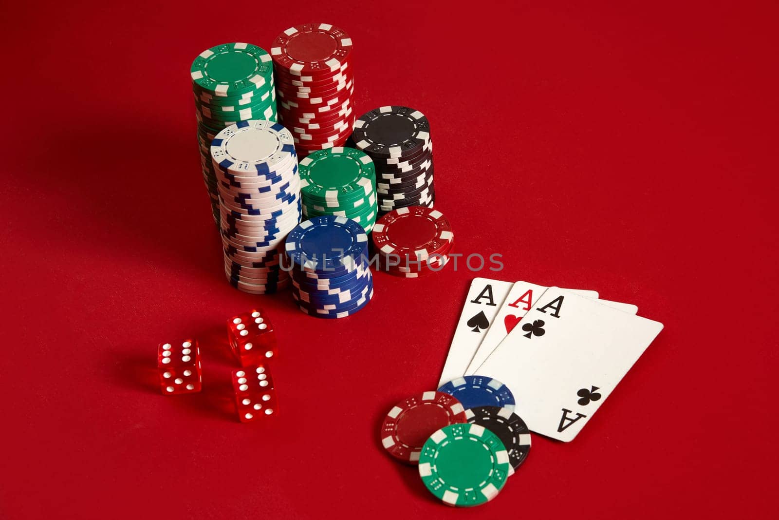 Casino gambling poker equipment and entertainment concept - close up of playing cards and chips at red background. Three of a Kind. Casino background. Copy space. Still life