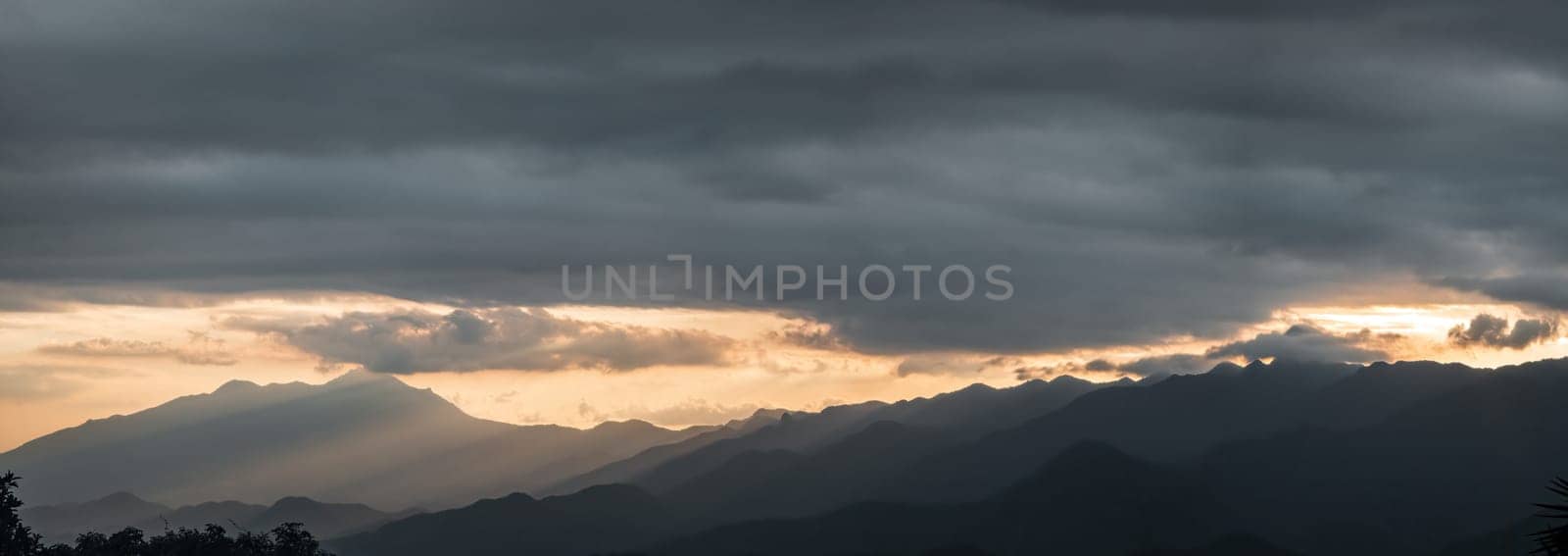 Majestic mountain range at sunset with sun rays and clouds by FerradalFCG