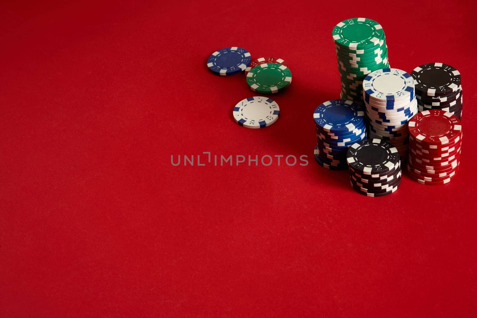 Poker chips on red background. Group of different poker chips. Casino background. Copy space. Still life
