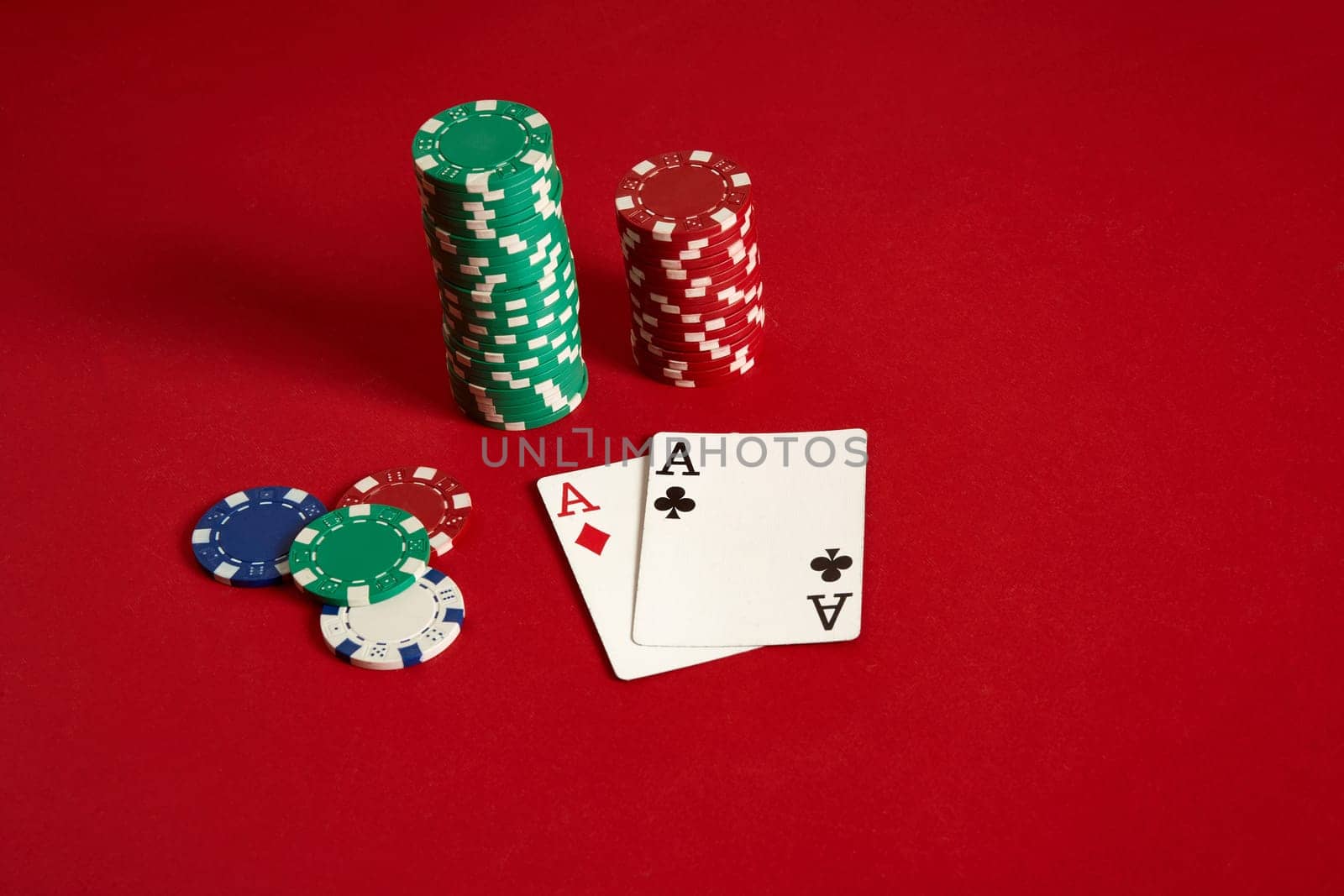 Poker chips and aces on red background. Group of different poker chips. Casino background. Copy space. Still life. One Pair