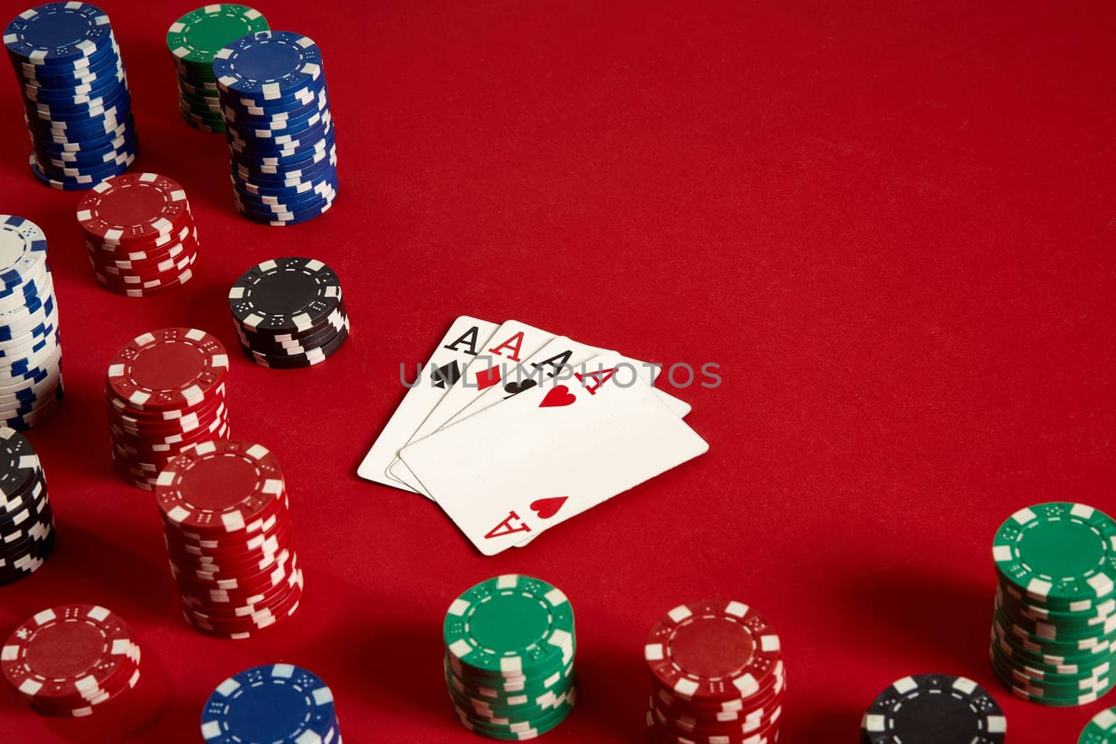 Poker cards and gambling chips on red background. Top view. Copy space. Still life. Flat lay. Cards - four aces. 4 of a kind